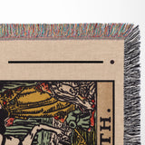 Close-up of a Death tarot card blanket with colorful fringe and a printed design featuring a horse.