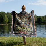 Person wearing a decorative Aries blanket by a lake