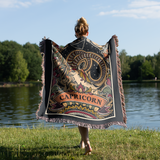 Person holding a Capricorn-themed blanket by a lake