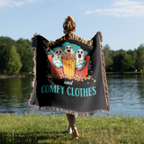 Person holding a blanket with ghosts and popcorn near a lake.
