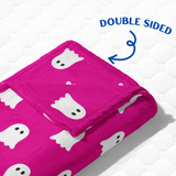 Folded pink blanket with ghost pattern on a white background