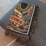 Decorative blanket with ' Capricorn ' text and colorful patterns on a gray surface.